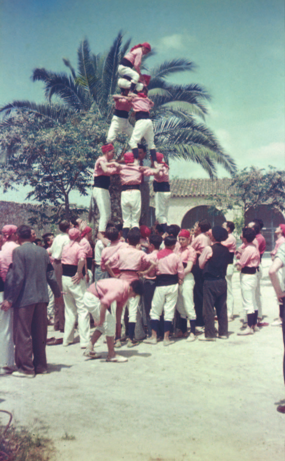 Al tronc d’aquest quatre de cinc net, hom pot observar la presència improvisada d’un casteller vestit de paisà, amb corbata i tot; vegi’s també com la majoria de castellers uniformats anaven amb calcilles negres